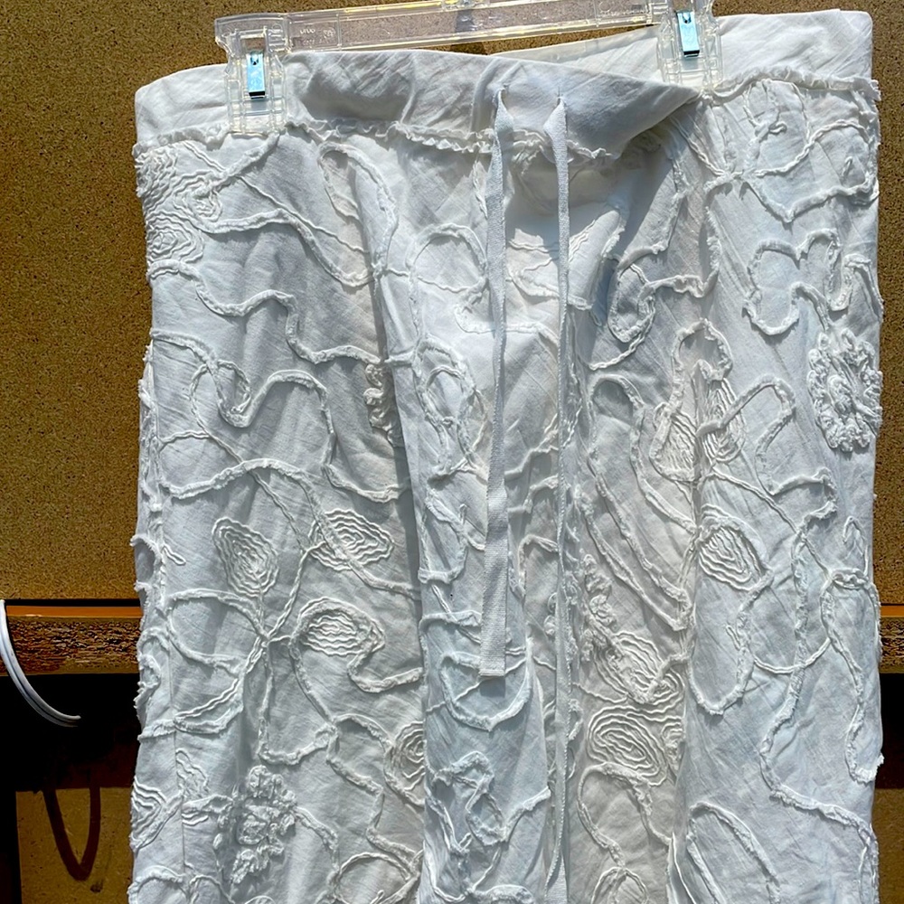 White mid-thigh skirt with raised designs.